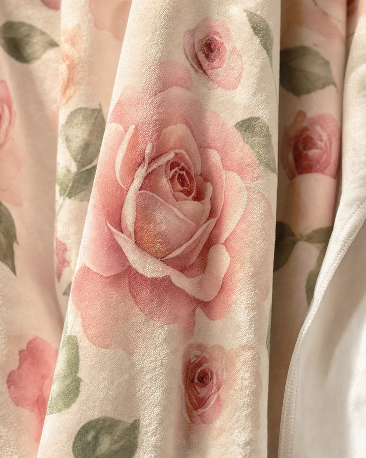 Close detail of the plush velveteen pile showing the watercolor roses printed into the nap and the stitched edge