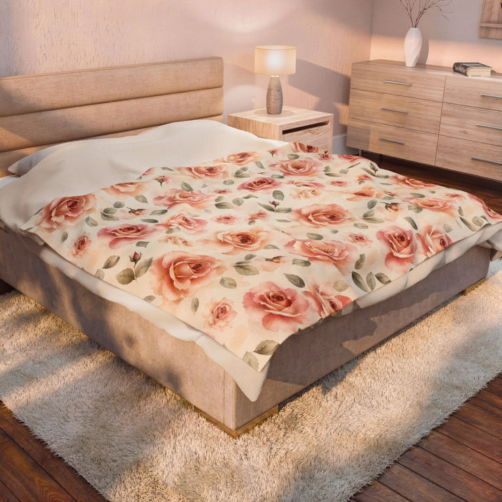 The blanket across a made bed in a softly lit bedroom
