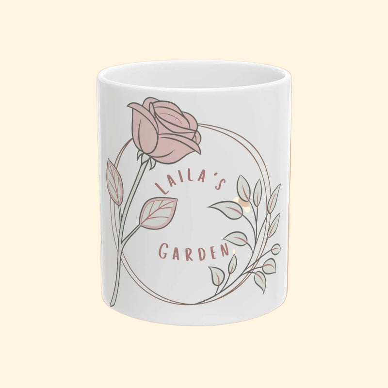 White mug with a pink rose design and 'Laila's Garden' text on a white background
